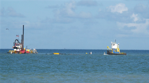 treasure island beach renourishment dredge in john's pass channel with tug boat